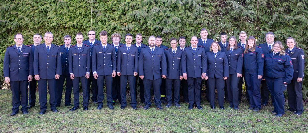 Gruppenbild in Ausgehuniform vor einer grünen Hecke