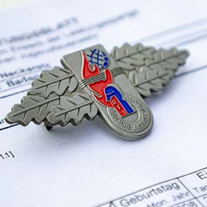 Ein Abzeichen "Jugendleistungsspange" liegt auf einem Formular